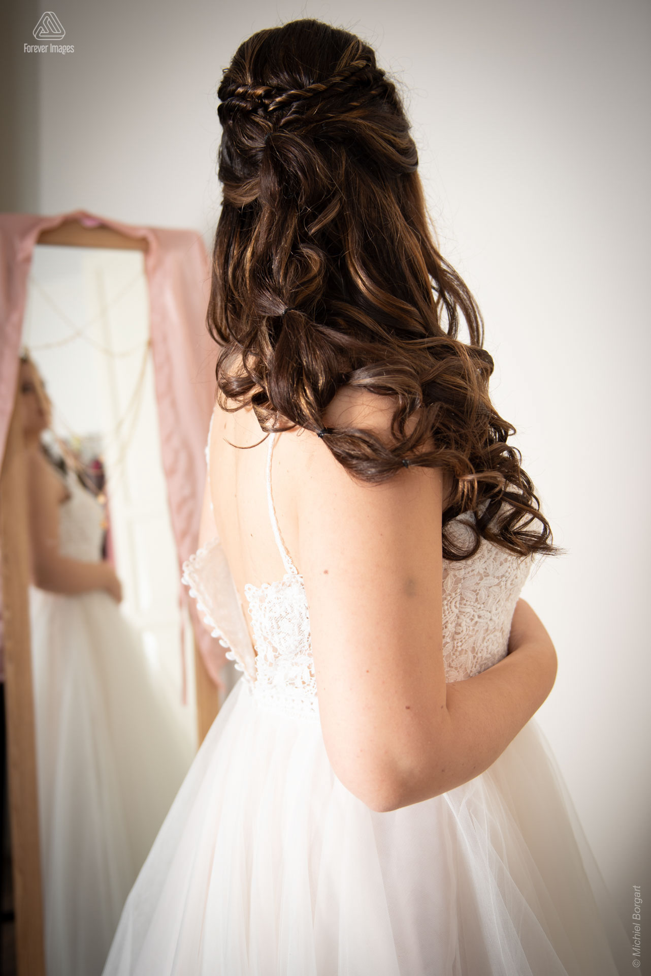 Wedding photo putting on wedding dress in front of mirror | Wedding Photographer Michiel Borgart - Forever Images.
