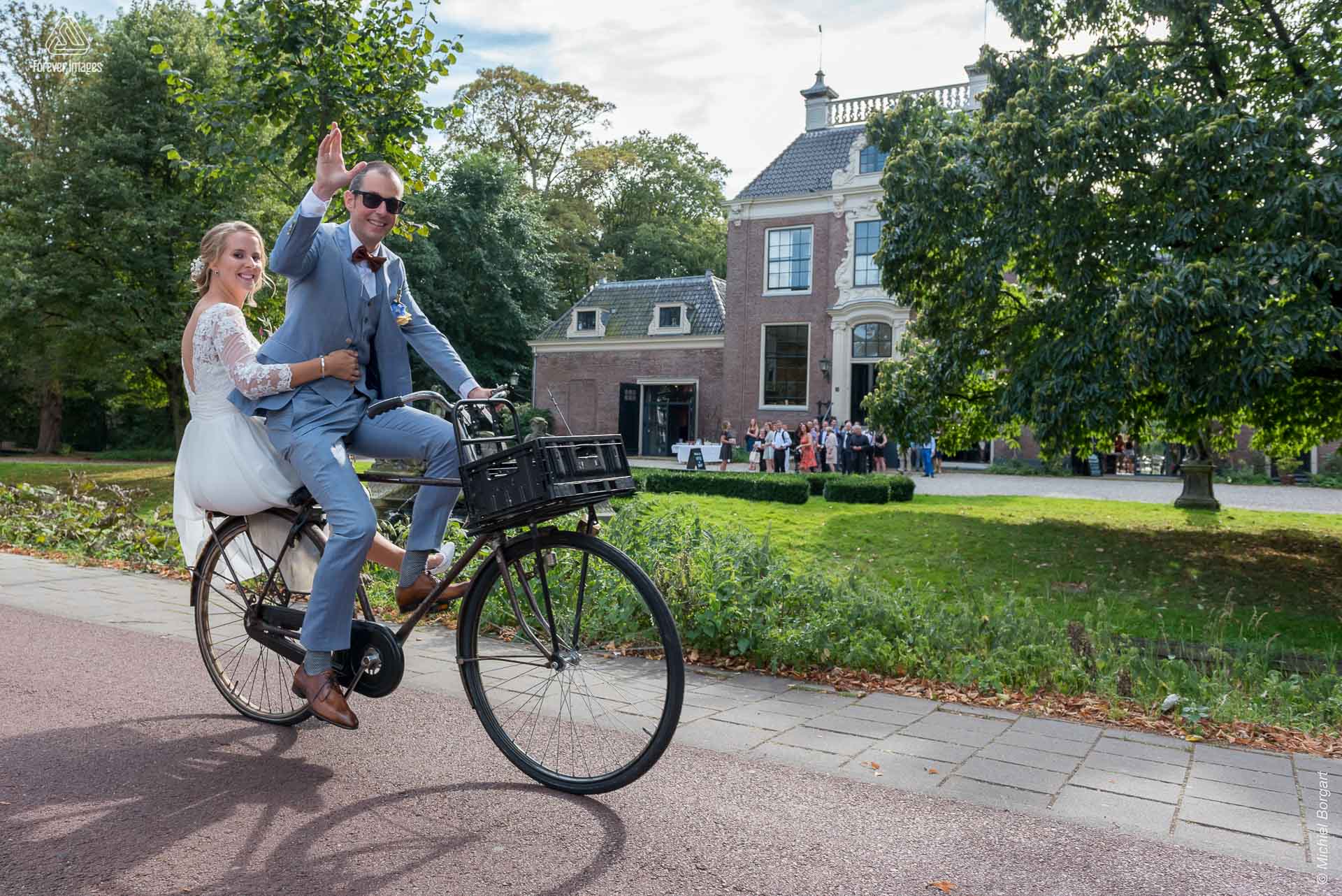 Bruidsfoto bruidspaar op de fiets onderweg naar het feest | Bart Eefje Mijland | Bruidsfotograaf Michiel Borgart - Forever Images.