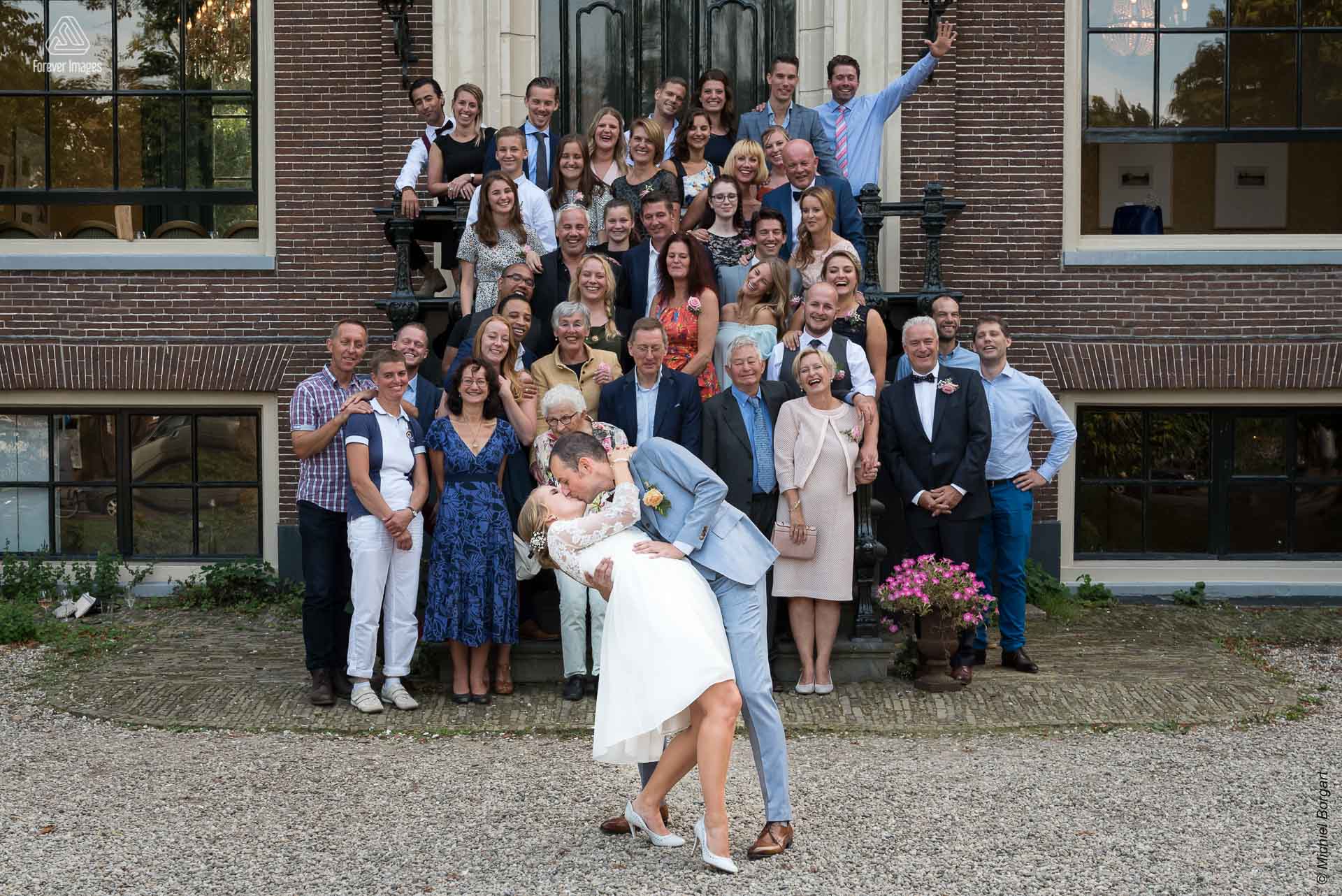 Bruidsfoto bruidspaar kust voor gasten bordes Huize Frankendael Amsterdam | Bart Eefje | Bruidsfotograaf Michiel Borgart - Forever Images.
