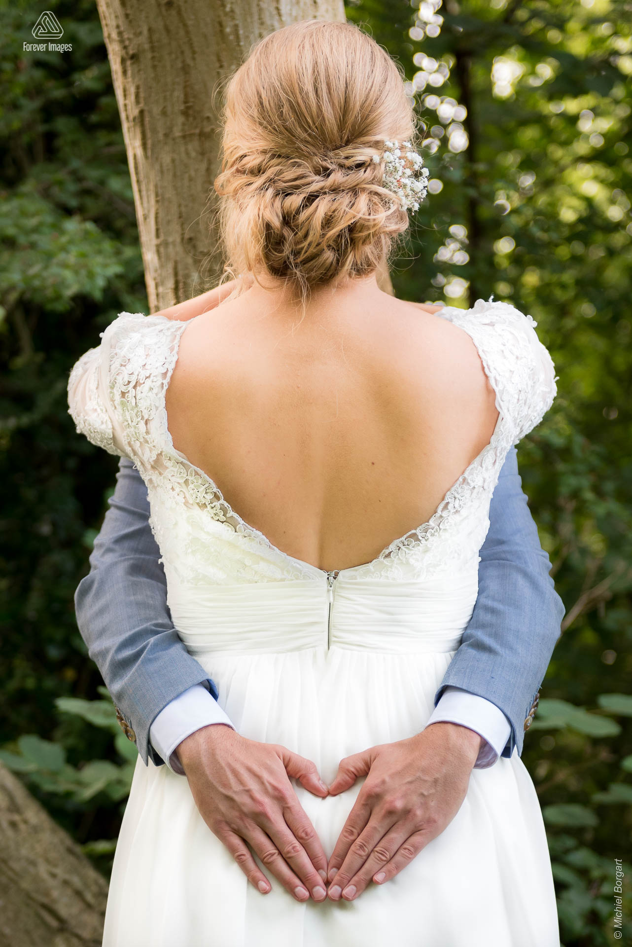 Bruidsfoto omarming waarbij de handen van de bruidegom hartje vormen | Bart Eefje Mijland | Bruidsfotograaf Michiel Borgart - Forever Images.