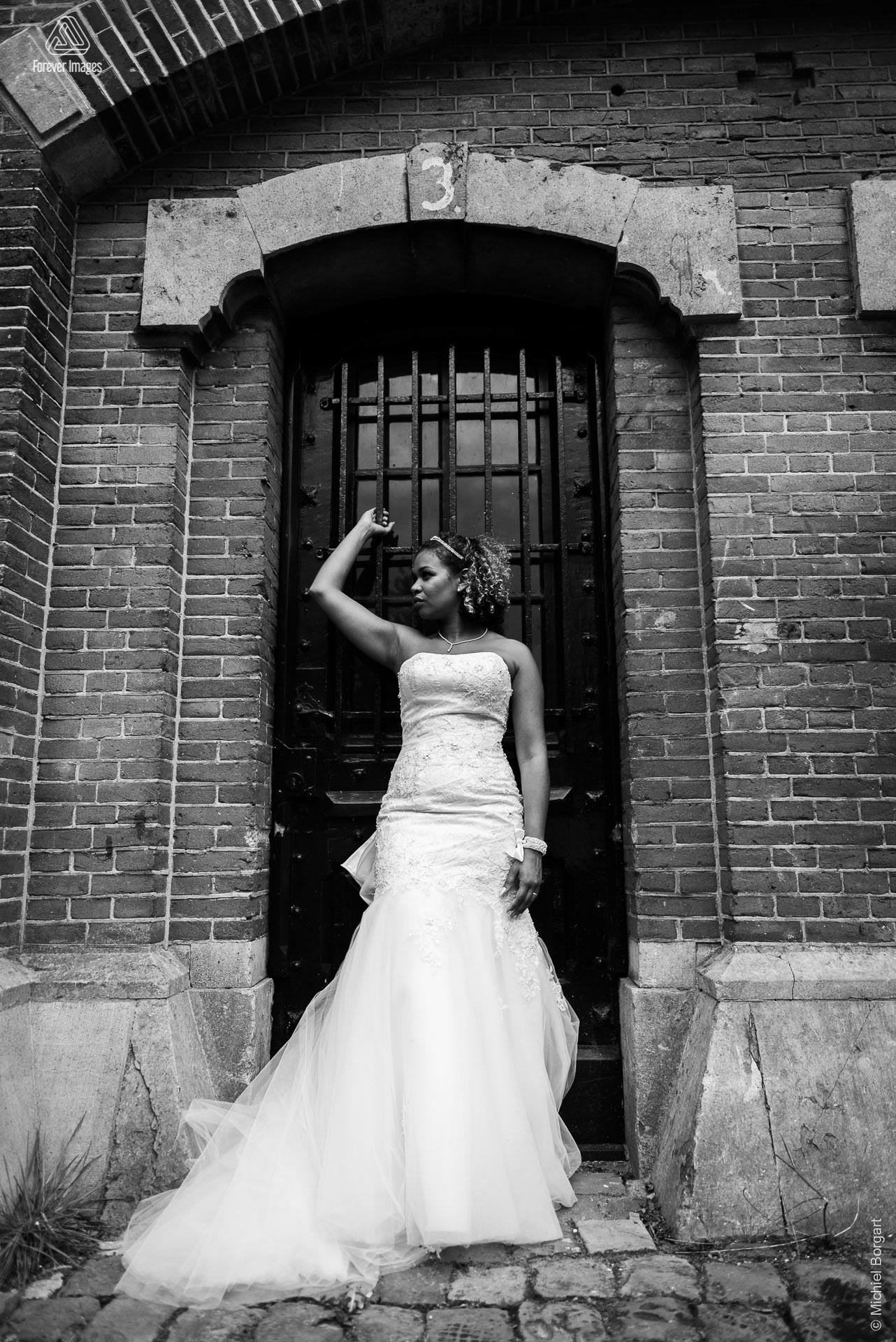 Bridal photo black and white guarding the gate | Kamiel Elseric | Wedding Photographer Michiel Borgart - Forever Images.