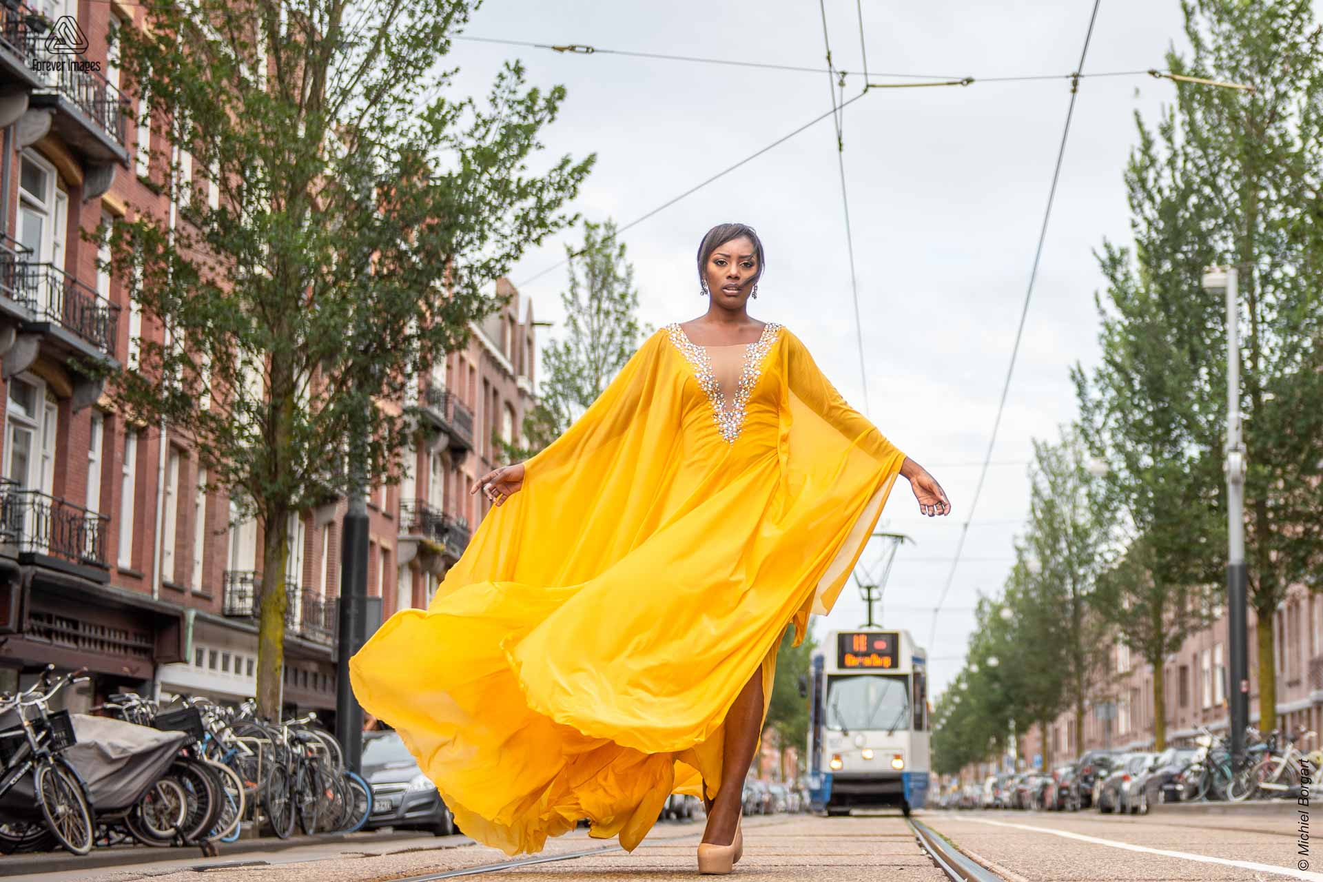Fashionfoto urben shoot gele jurk tram Amsterdam | Mariana Pietersz David Cardenas Miss Avantgarde | Fashionfotograaf Michiel Borgart - Forever Images.
