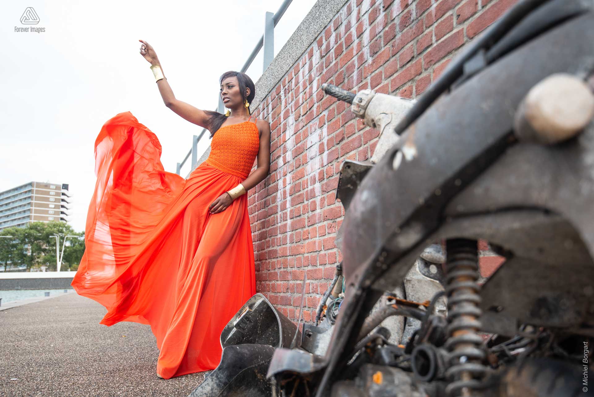 Fashionfoto urben shoot oranje jurk muur Amsterdam | Mariana Pietersz David Cardenas Miss Avantgarde | Fashionfotograaf Michiel Borgart - Forever Images.
