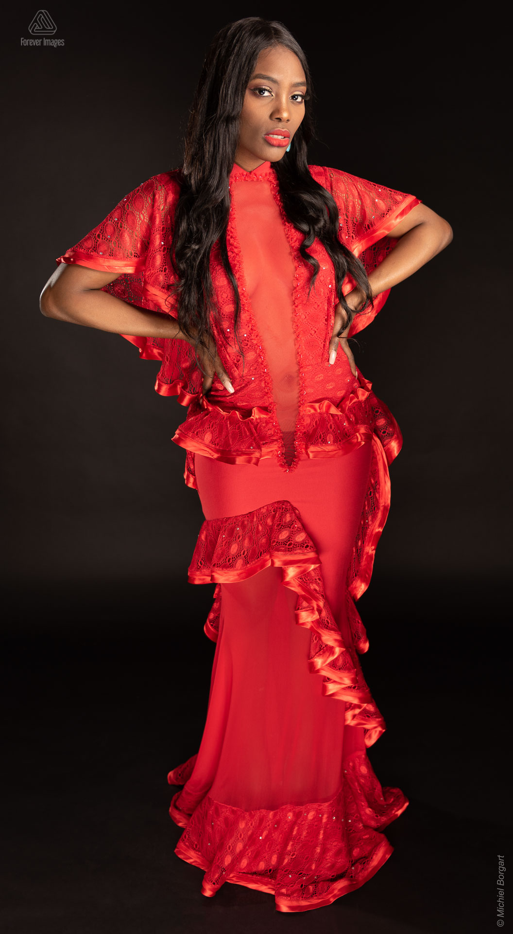 Fashionfoto rode jurk totaal handen in zij | Mariana Pietersz Miss Avantgarde Ronald Rizzo Piu Colore | Fashionfotograaf Michiel Borgart - Forever Images.