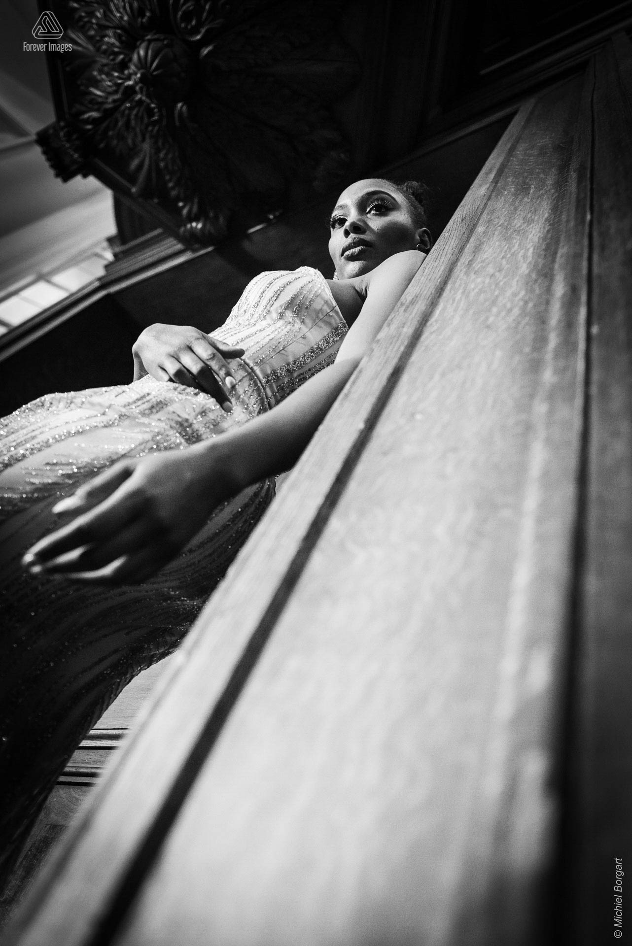 Fashionfoto zwart-wit galajurk leunend in deurpost | Mariana Pietersz Duc Nguyen Koepelkerk Amsterdam | Fashionfotograaf Michiel Borgart - Forever Images.