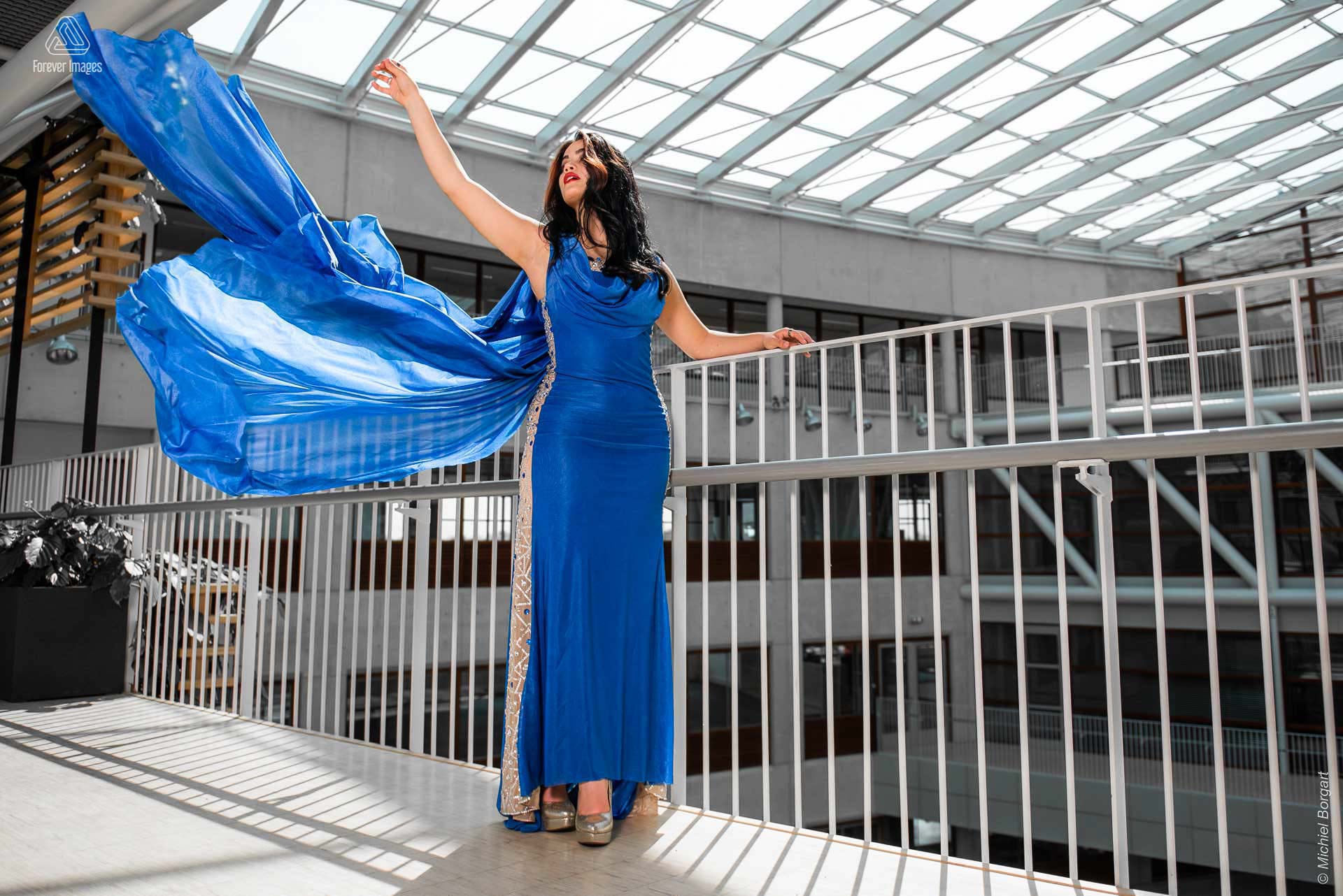 Fashionfoto glamour mooie dame op balustrade blauwe jurk | Daphna Akkermans David Cardenas | Fashionfotograaf Michiel Borgart - Forever Images.