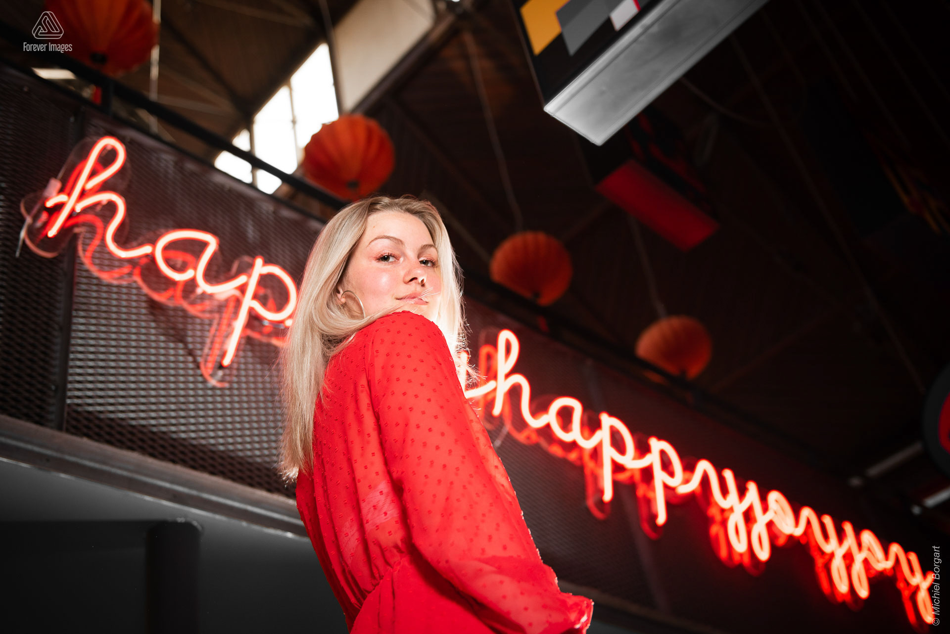 Portretfoto jonge dame in rode jurk voor neon tekst | Porscha Luna de Jong Happyhappyjoyjoy | Portretfotograaf Michiel Borgart - Forever Images.