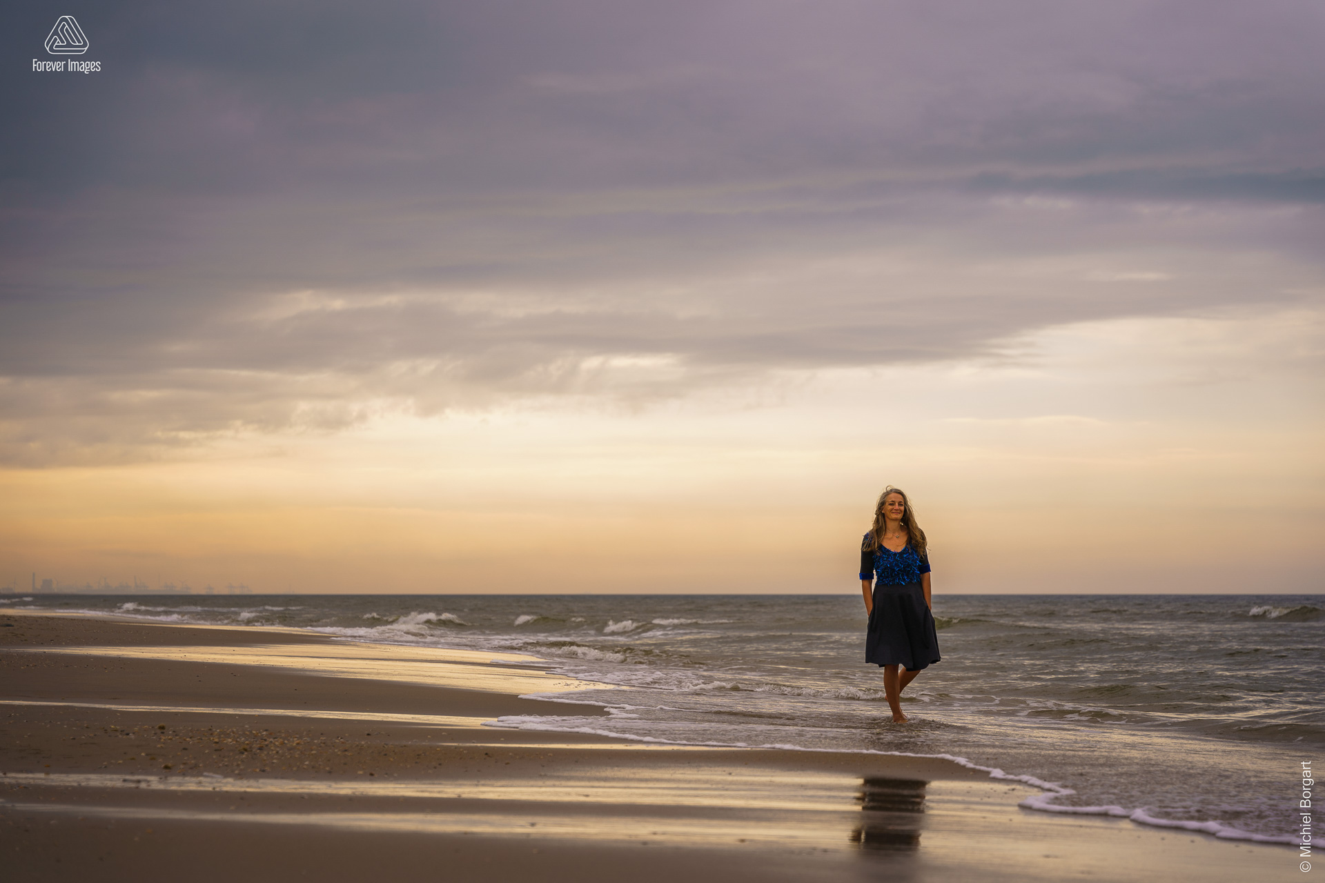 Portretfoto dame wandelt door het water Noordzee Kijkduin | Esther Echt Eigenwijs | Portretfotograaf Michiel Borgart - Forever Images.