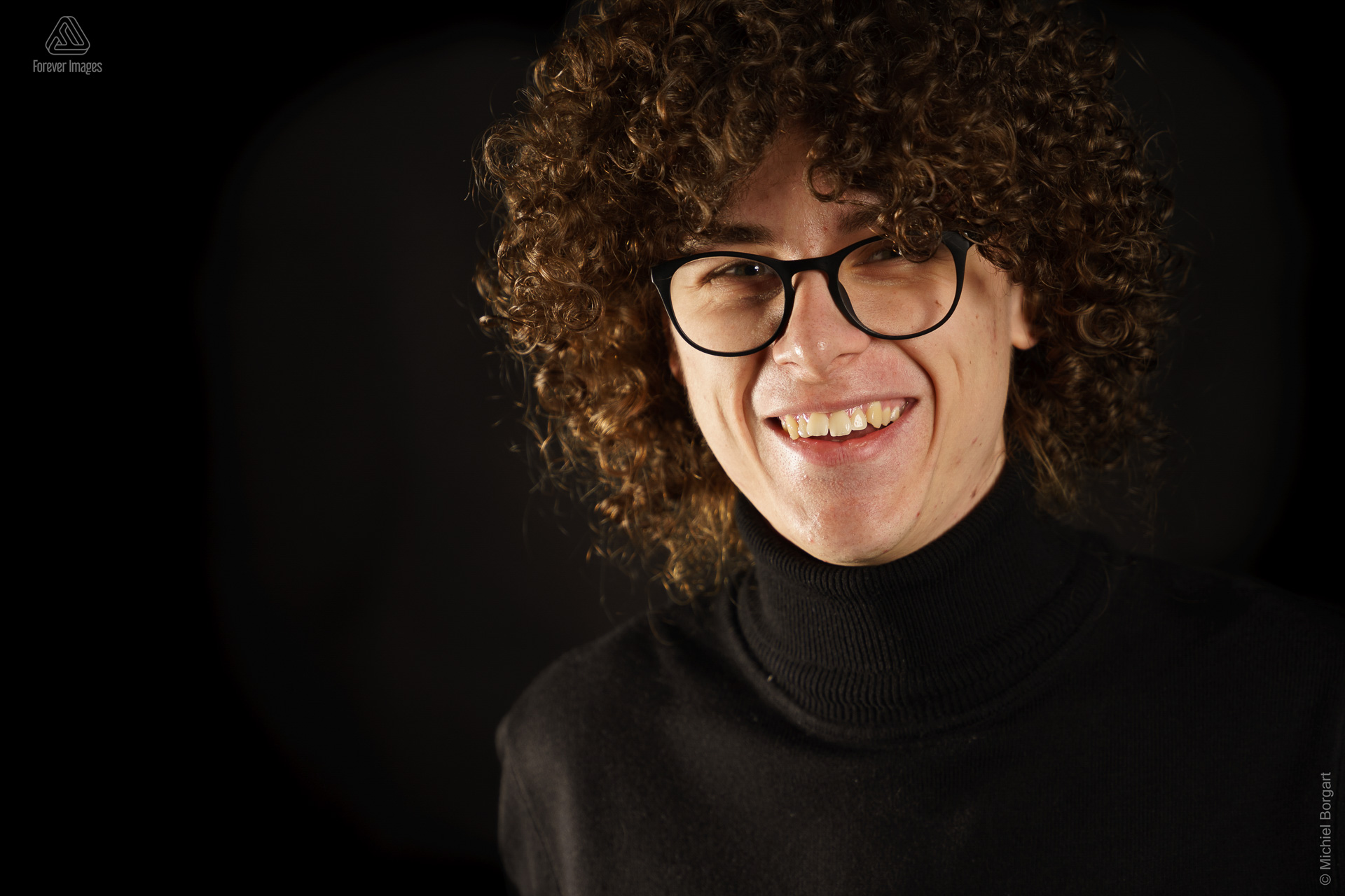 Portrait photo young man with black turtleneck glasses and long curly hair | Andreas | Portrait Photographer Michiel Borgart - Forever Images.