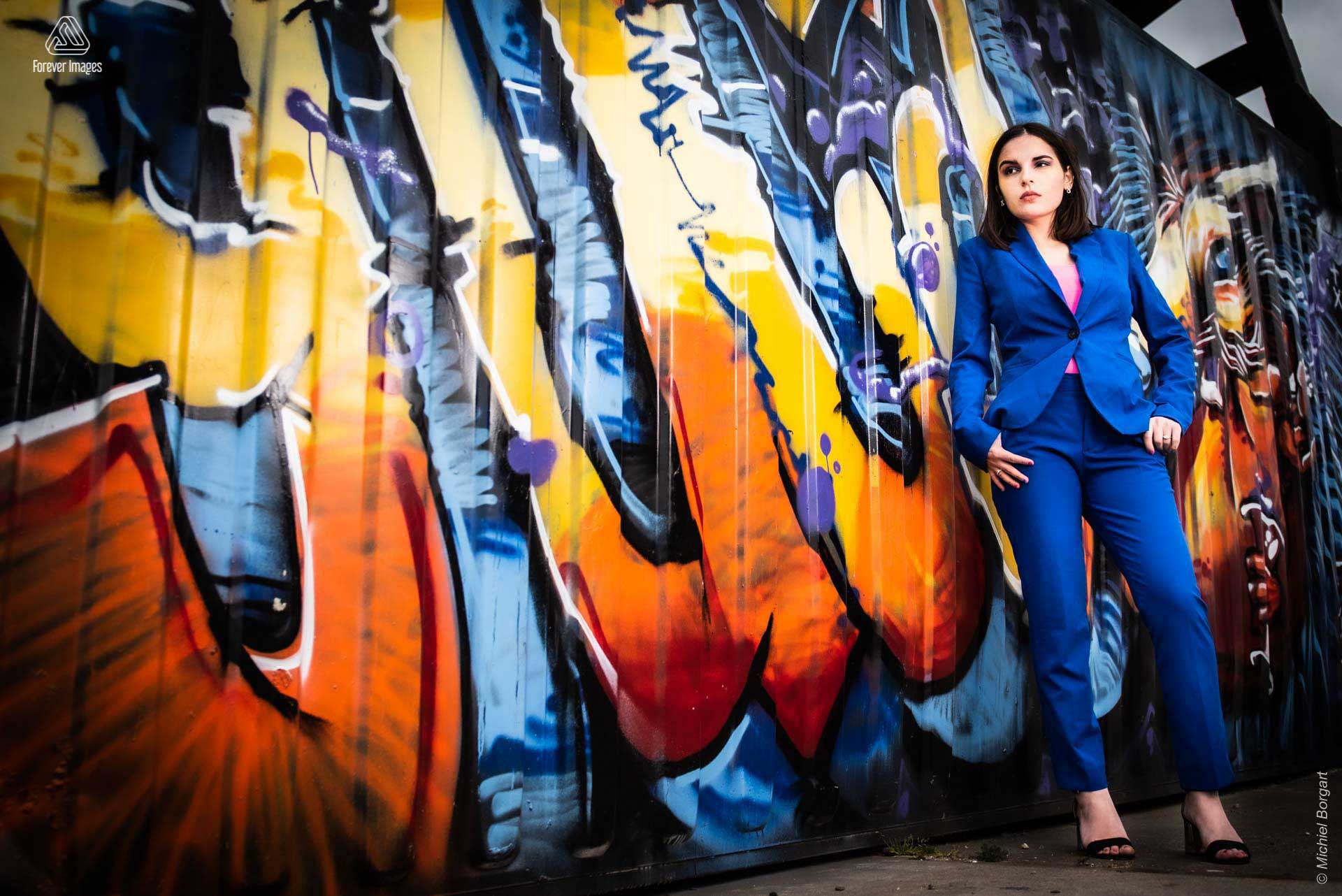 Portrait photo of a lady in blue suit graffiti sea container | Isis Vaandrager NDSM Werf Amsterdam | Portrait Photographer Michiel Borgart - Forever Images.