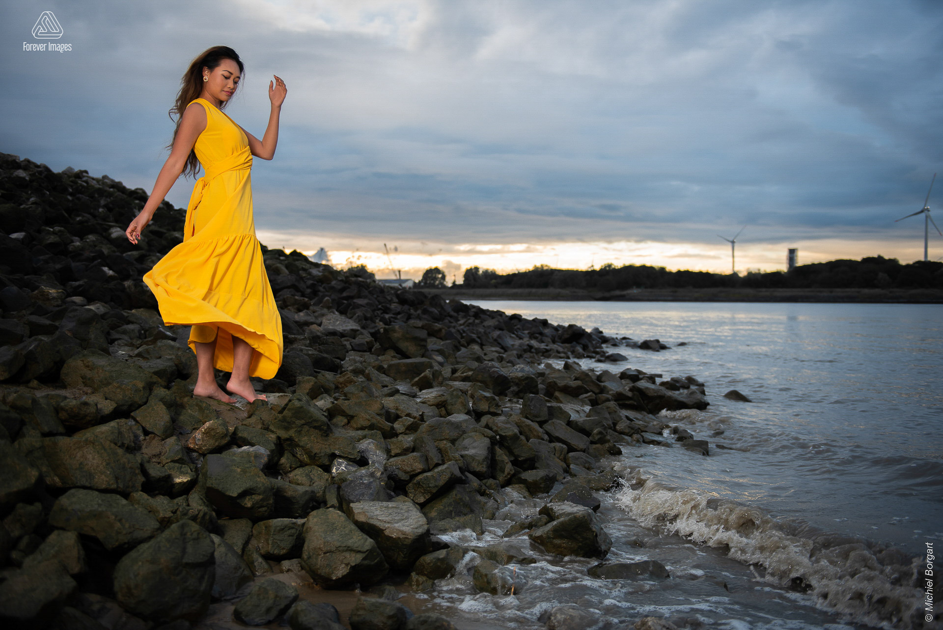 Fashion photo yellow dress on boulders on the shore | Carolyn Collinda Sint Annastrand Linkeroever | Portrait Photographer Michiel Borgart - Forever Images.