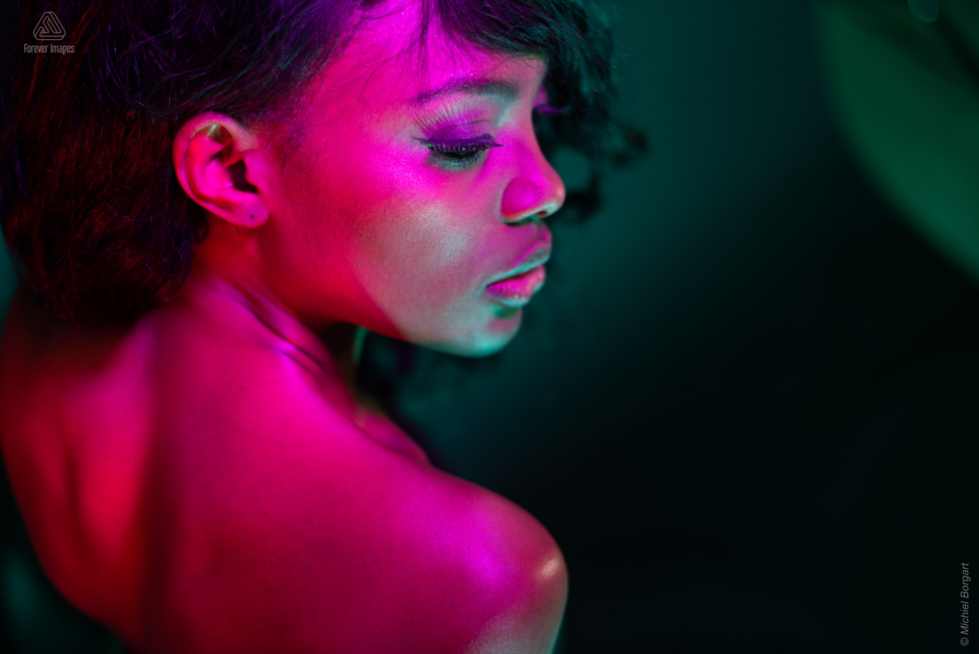Portretfoto model paars rood groen licht achter over schouder low key | Mariana Pietersz Miss Avantgarde | Portretfotograaf Michiel Borgart - Forever Images.