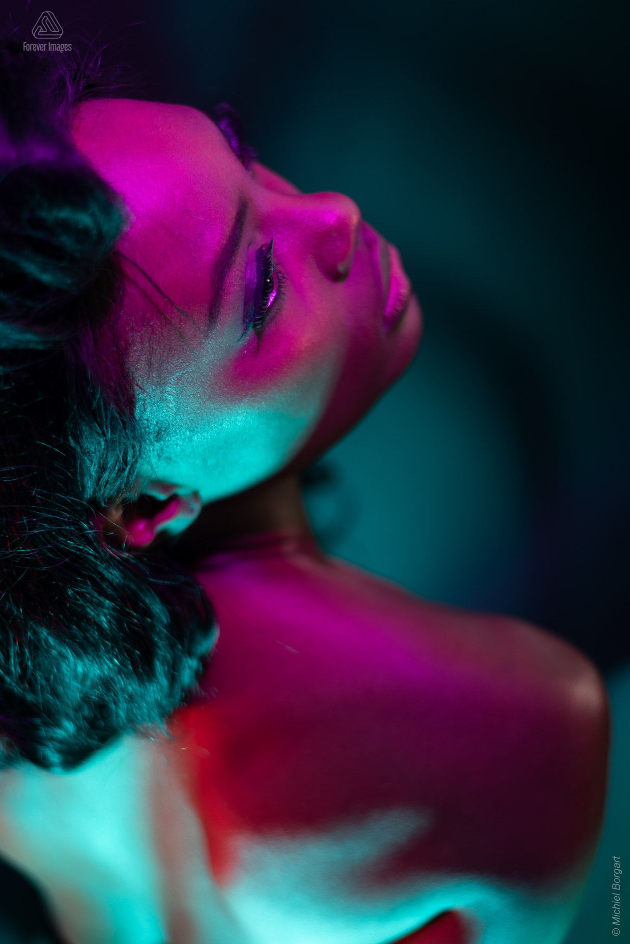 Portretfoto model paars rood groen licht achter omhoog kijken low key | Mariana Pietersz Miss Avantgarde | Portretfotograaf Michiel Borgart - Forever Images.