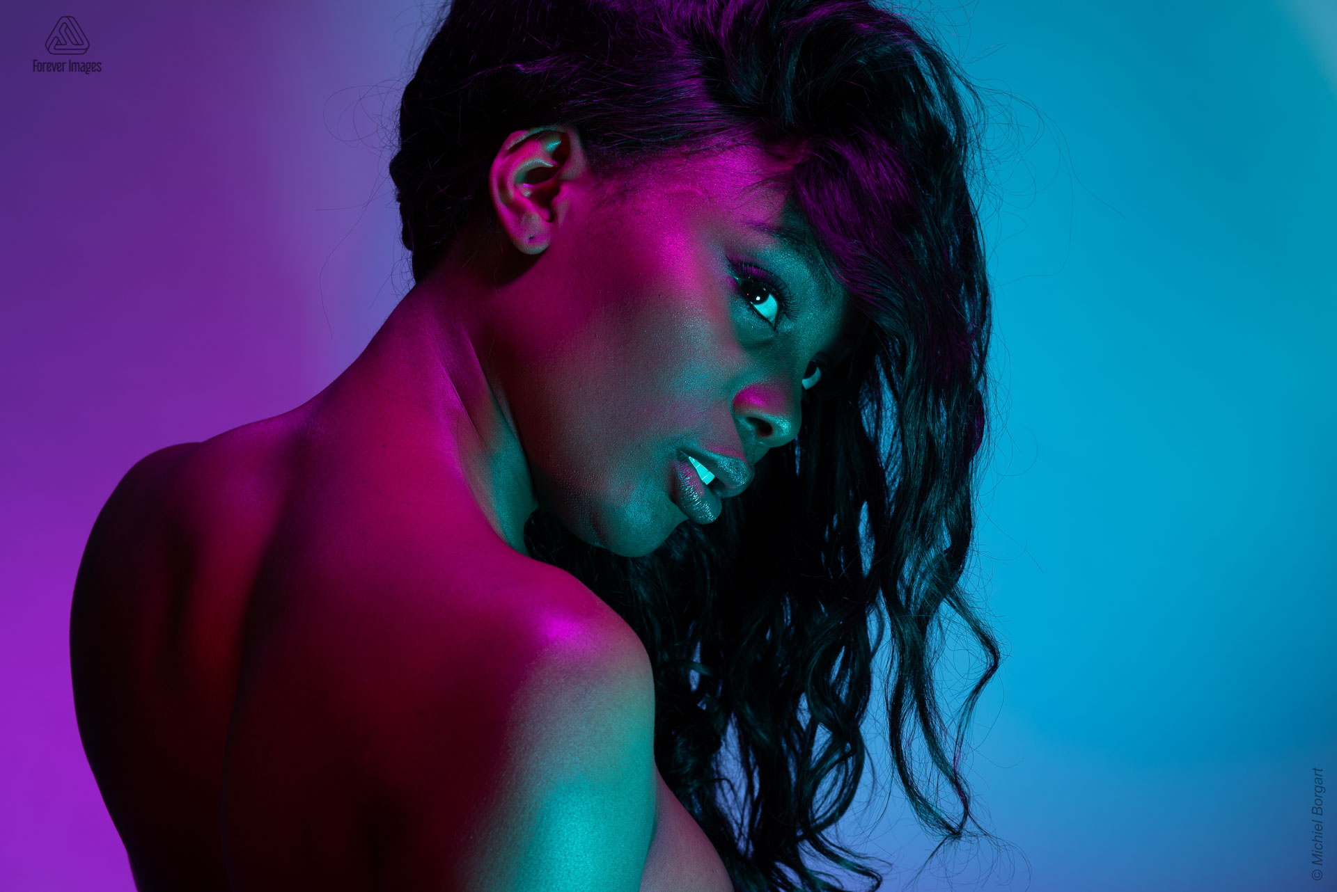 Portretfoto model paars rood groen licht mooie rug naar achter kijken | Mariana Pietersz Miss Avantgarde | Portretfotograaf Michiel Borgart - Forever Images.