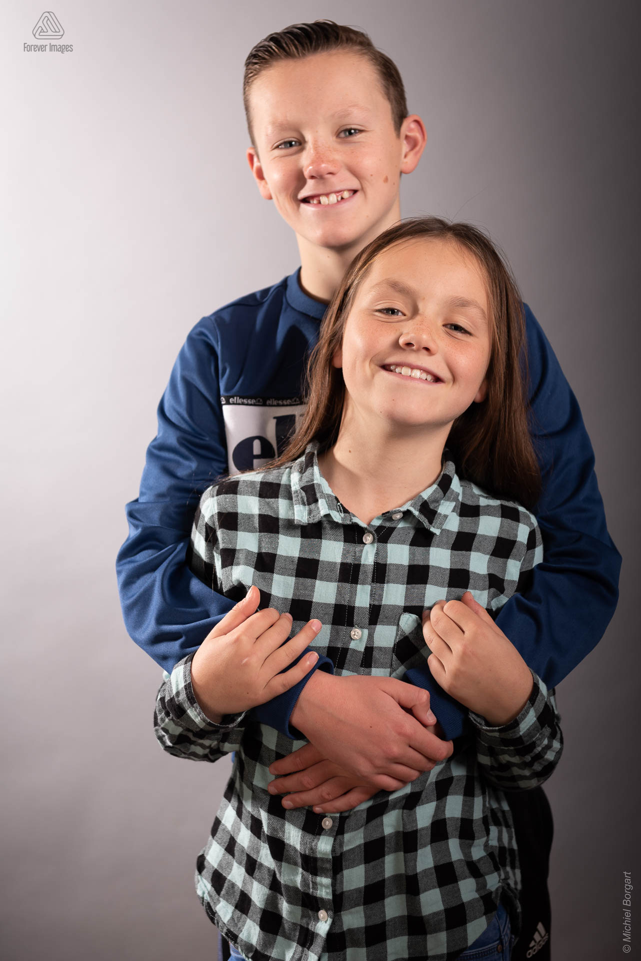 Portretfoto grote broer met zus in zijn armen | Portretfotograaf Michiel Borgart - Forever Images.