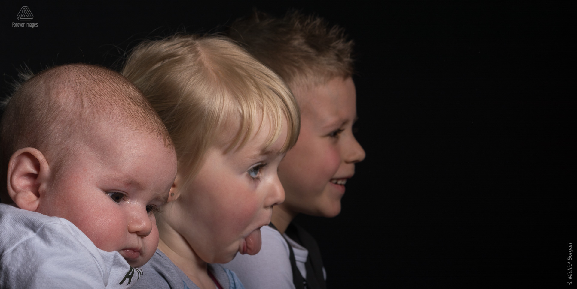 Kinderfoto broertjes en zusje waarbij het meisje haar tong uitsteekt | Noah Kayleigh-Sophie Elias | Portretfotograaf Michiel Borgart - Forever Images.