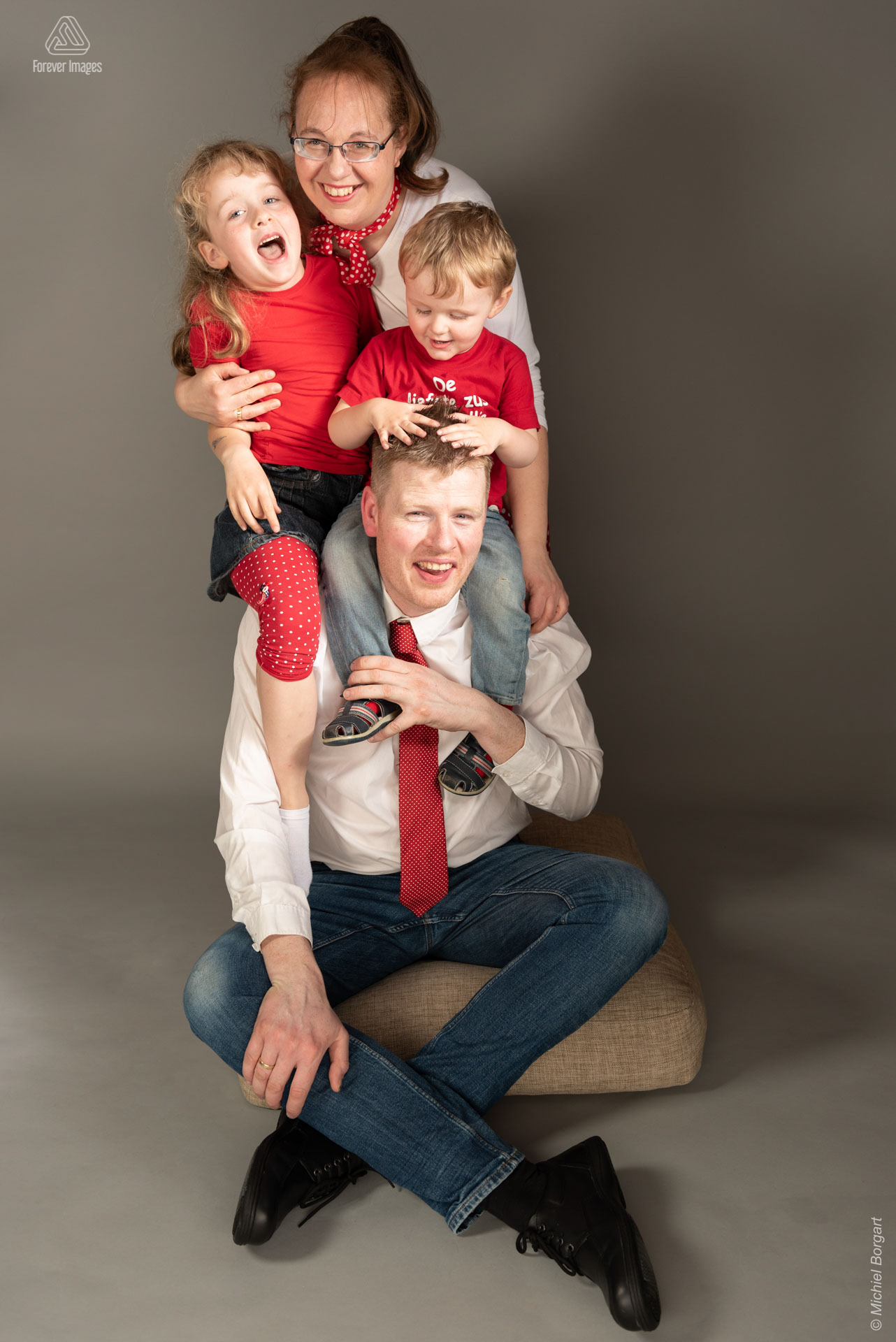 Vrolijk familieportret allemaal in wit rood gekleed | Familie Ben | Portretfotograaf Michiel Borgart - Forever Images.