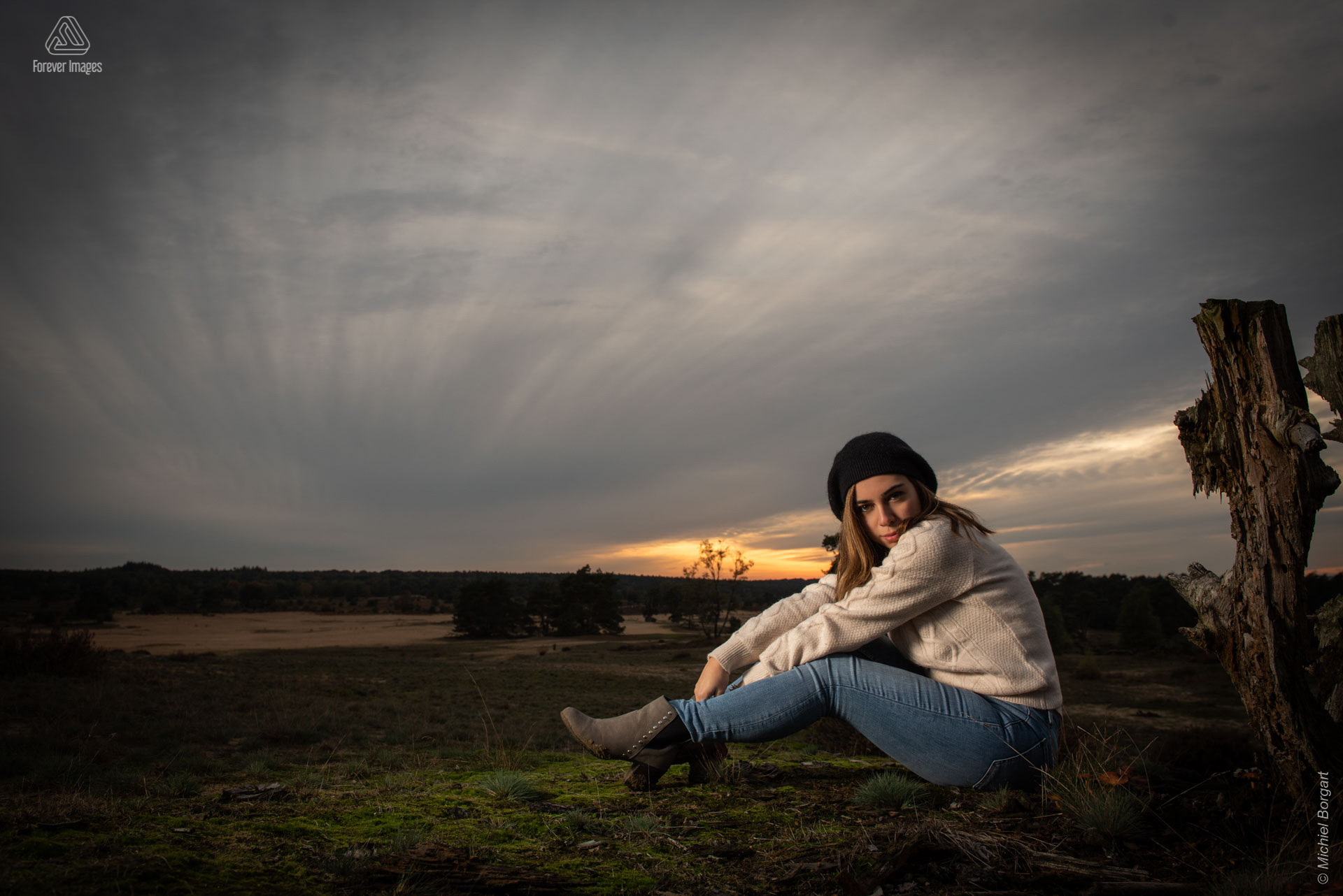 Portrait photo lady sitting next to sunset tree stump | Annalisa Veluwezoom | Portrait Photographer Michiel Borgart - Forever Images.