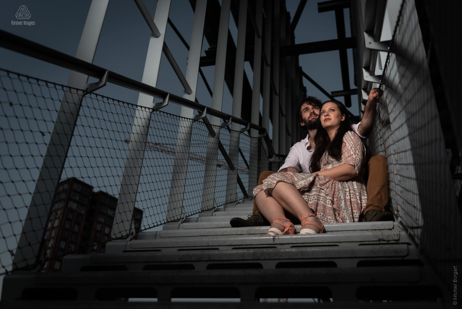 Portrait photo couple sits on steel stairs | Strijp | Portrait Photographer Michiel Borgart - Forever Images.