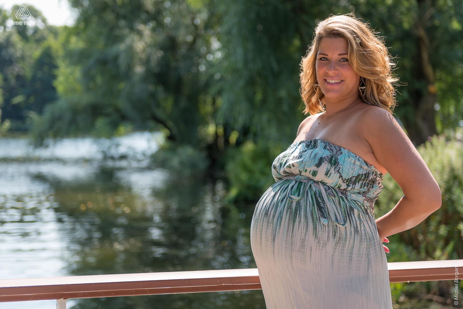 Zwangerschapsfoto jonge moeder buiten in het park op brug in de zon | Simone t Hooft-Creutzburg | Portretfotograaf Michiel Borgart - Forever Images.