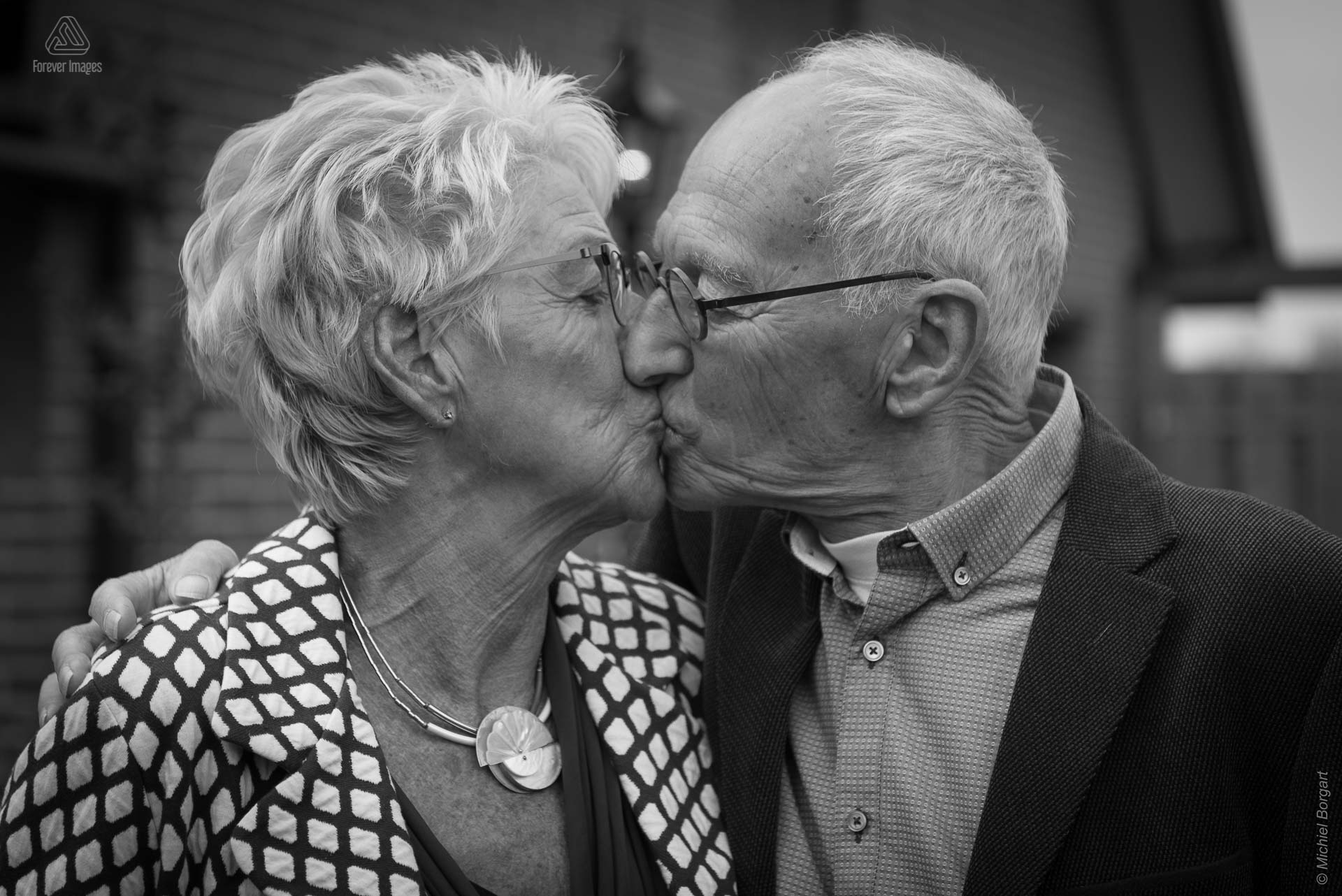 Loveshoot zwart-witfoto oud echtpaar kussend in tuin | Portretfotograaf Michiel Borgart - Forever Images.