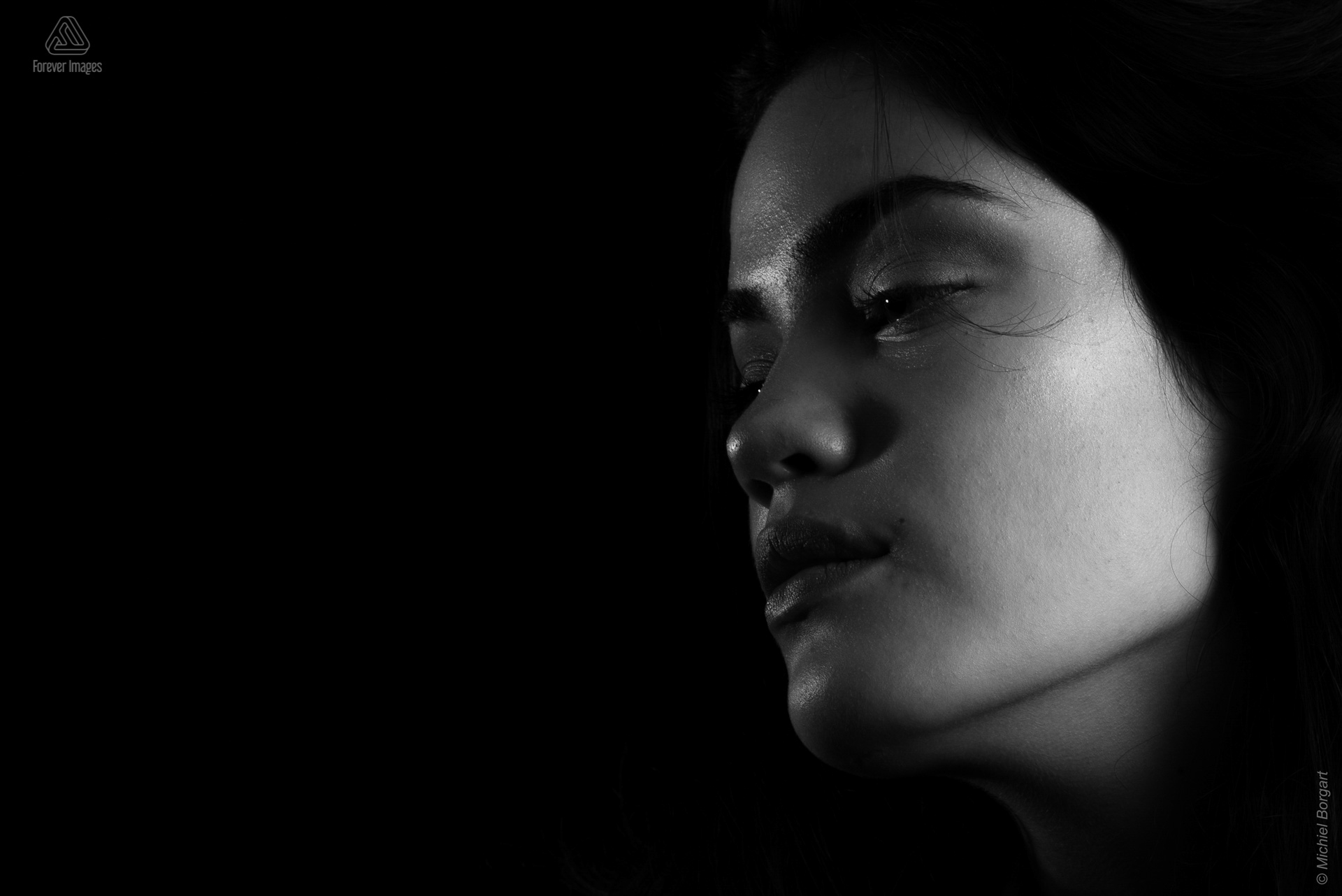 Portretfoto zwart-wit jonge dame mooie kaaklijn low key | Daphna Akkermans Isis Vaandrager | Portretfotograaf Michiel Borgart - Forever Images.