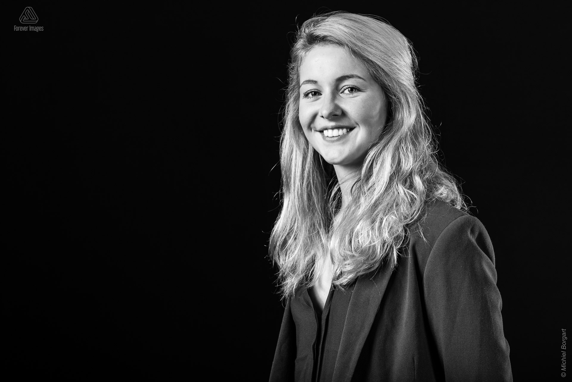 Portretfoto in zwart-wit mooie jonge blonde dame met jasje aan | Nicolette Nijhuis | Portretfotograaf Michiel Borgart - Forever Images.