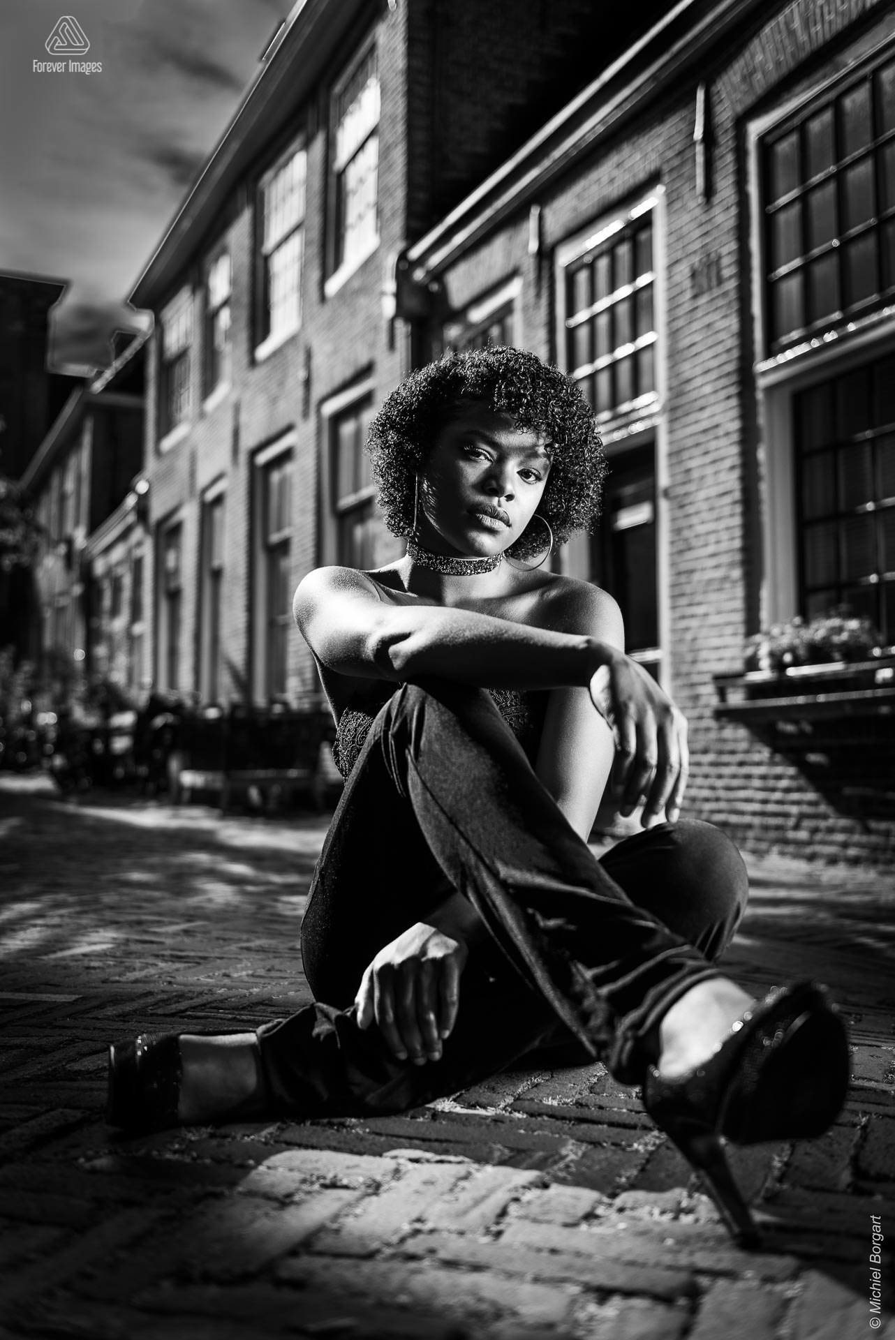 Portretfoto zwart-wit op straat zittend | Mariangel Dolorita Haarlem | Portretfotograaf Michiel Borgart - Forever Images.