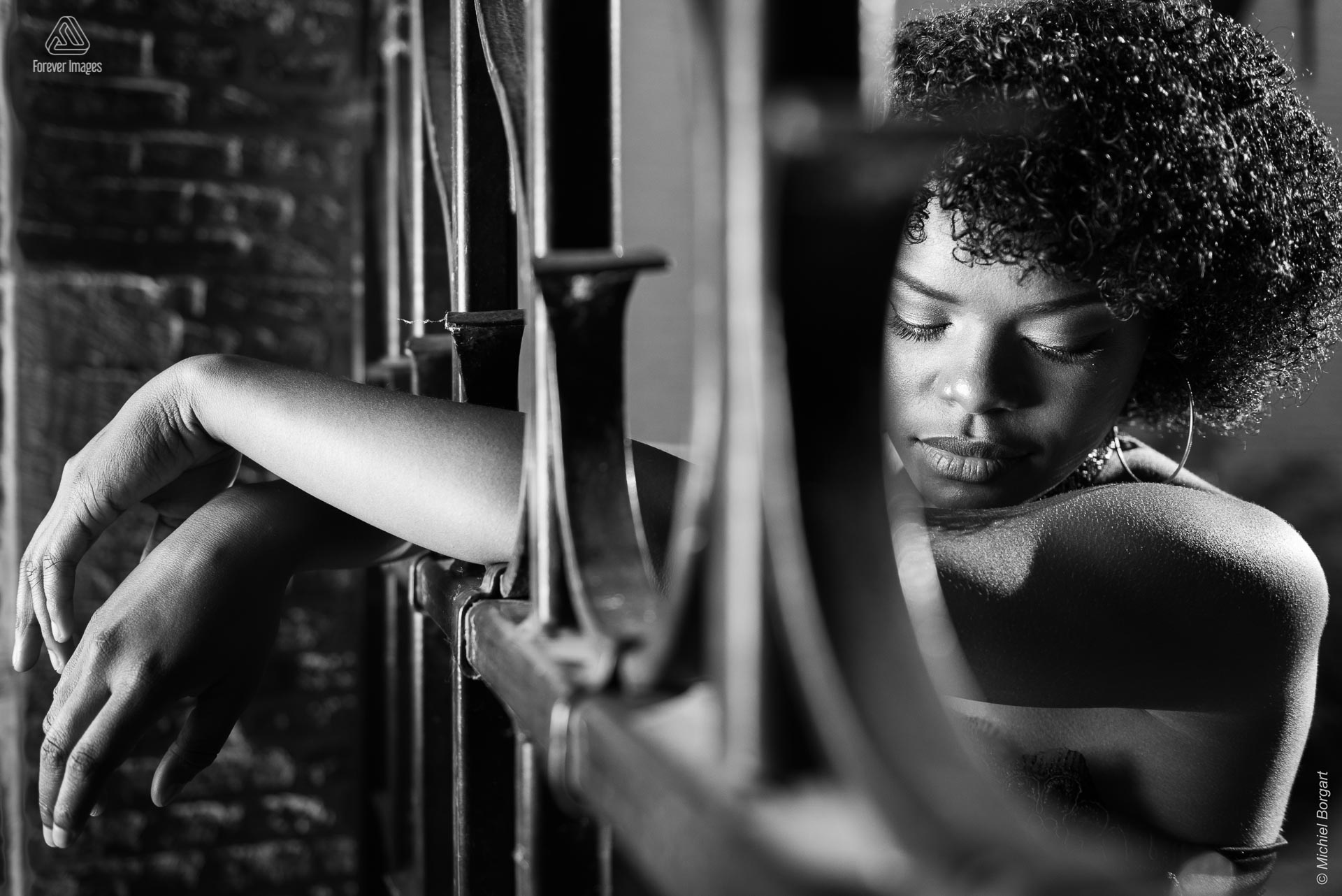 Portretfoto zwart-wit armen door hek | Mariangel Dolorita Haarlem | Portretfotograaf Michiel Borgart - Forever Images.