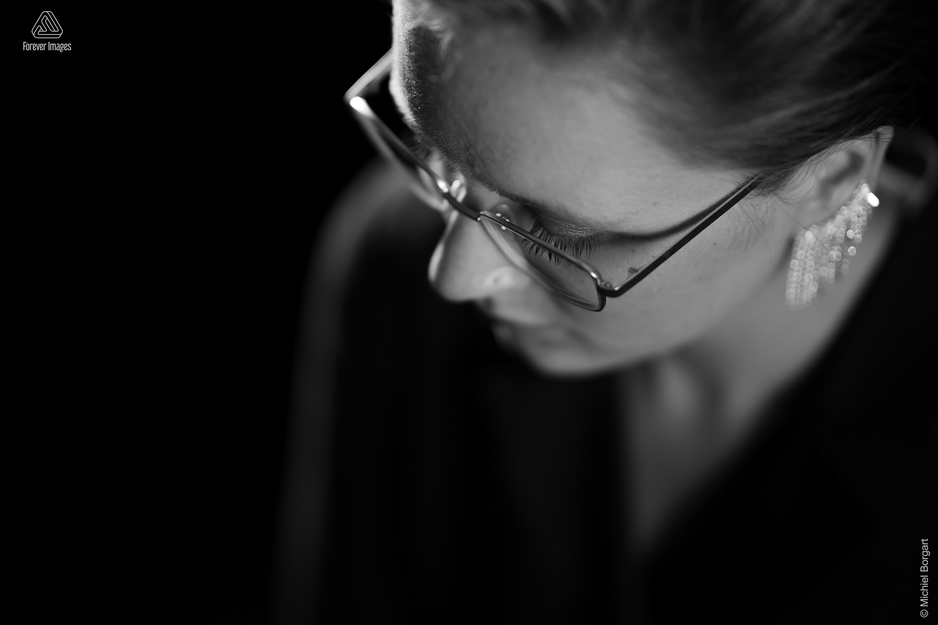 Portrait photo black and white B&W young lady close up from above with glasses and earrings | Carmen | Portrait Photographer Michiel Borgart - Forever Images.