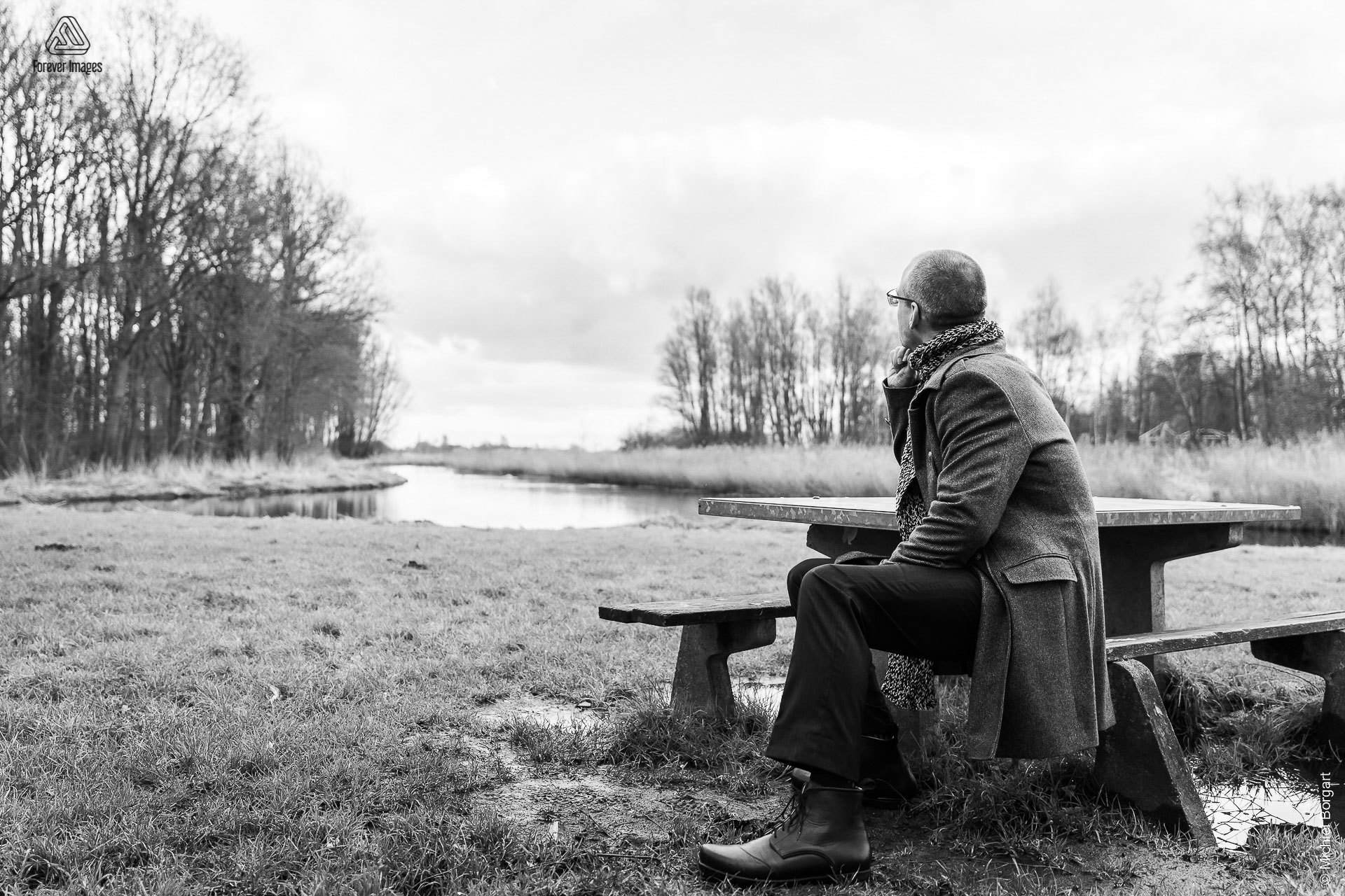 Portrait photo black and white B&W man sitting in park looking out over water | Robin Het Twiske De Stootersplas | Portrait Photographer Michiel Borgart - Forever Images.