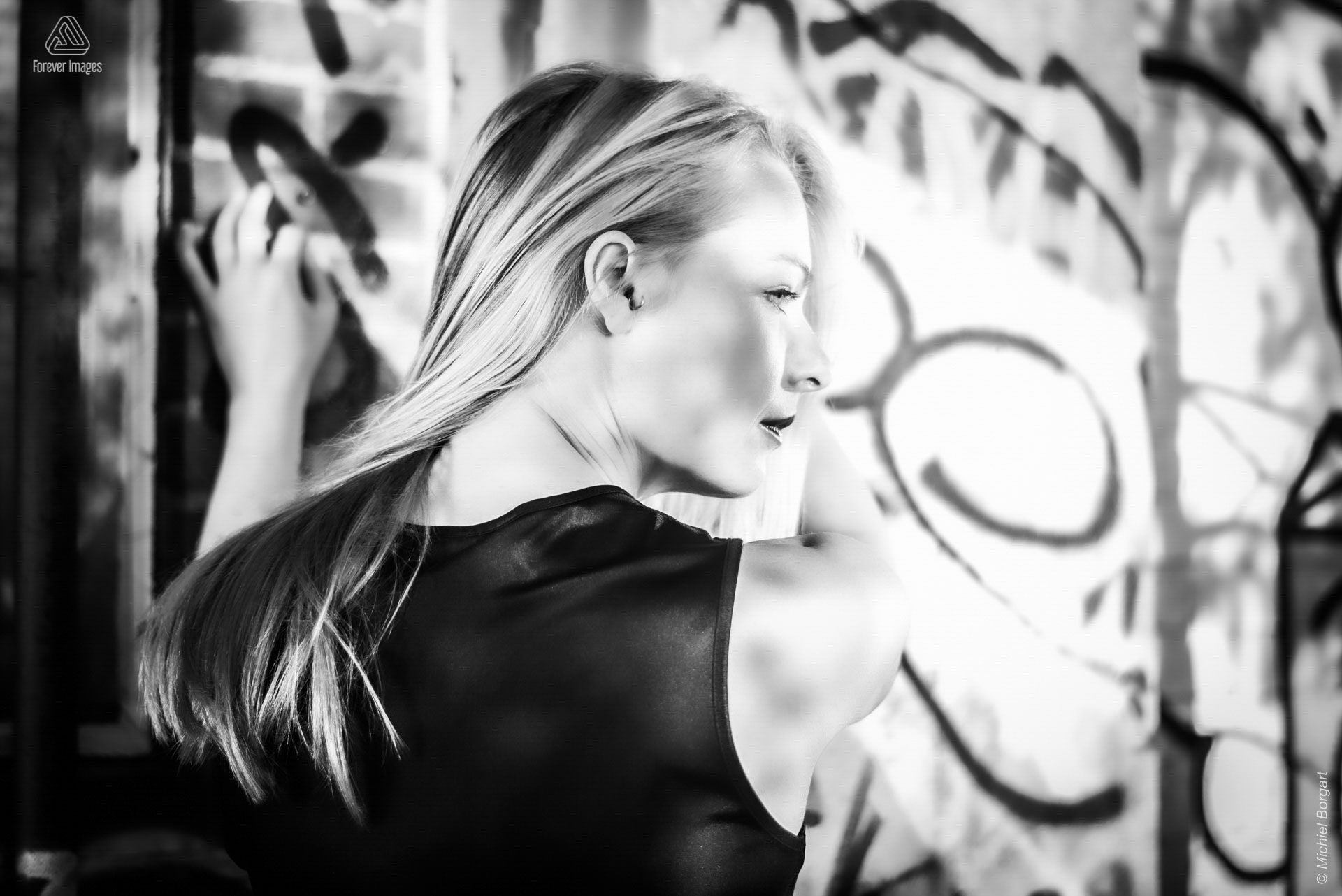 Portretfoto zwart-wit dame tussen graffiti | Heleen Muchachabiker NDSM Werf | Portretfotograaf Michiel Borgart - Forever Images.